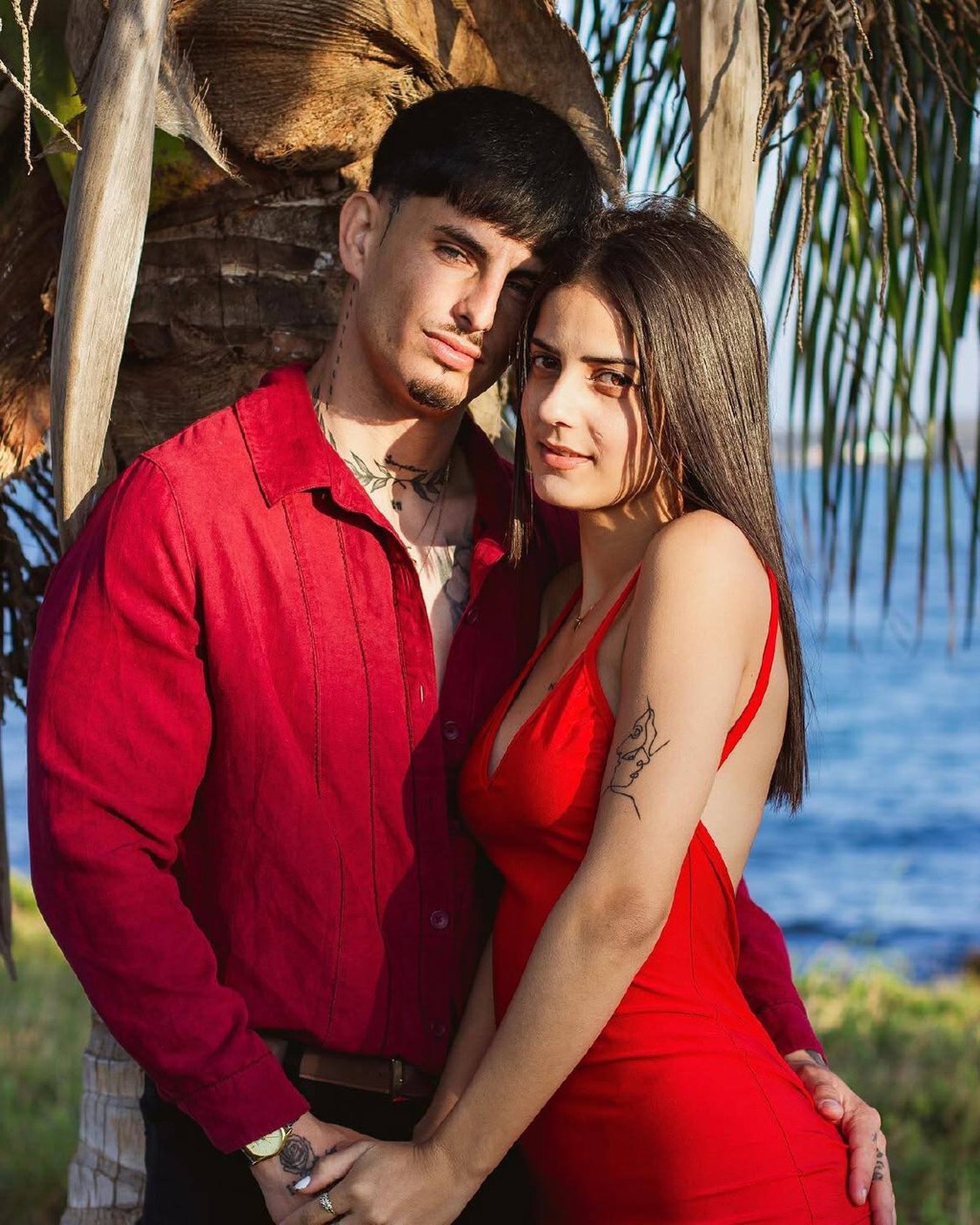 Retrato editorial de pareja junto a una palmera frente al mar