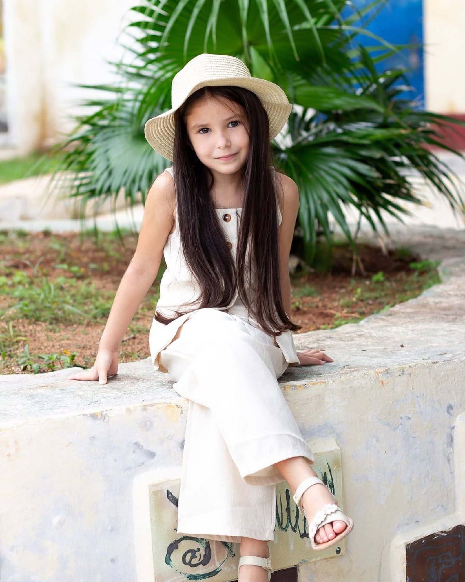 Retrato de niña con sombrero de paja en exterior